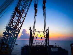 offshore oil rig with sunset in background